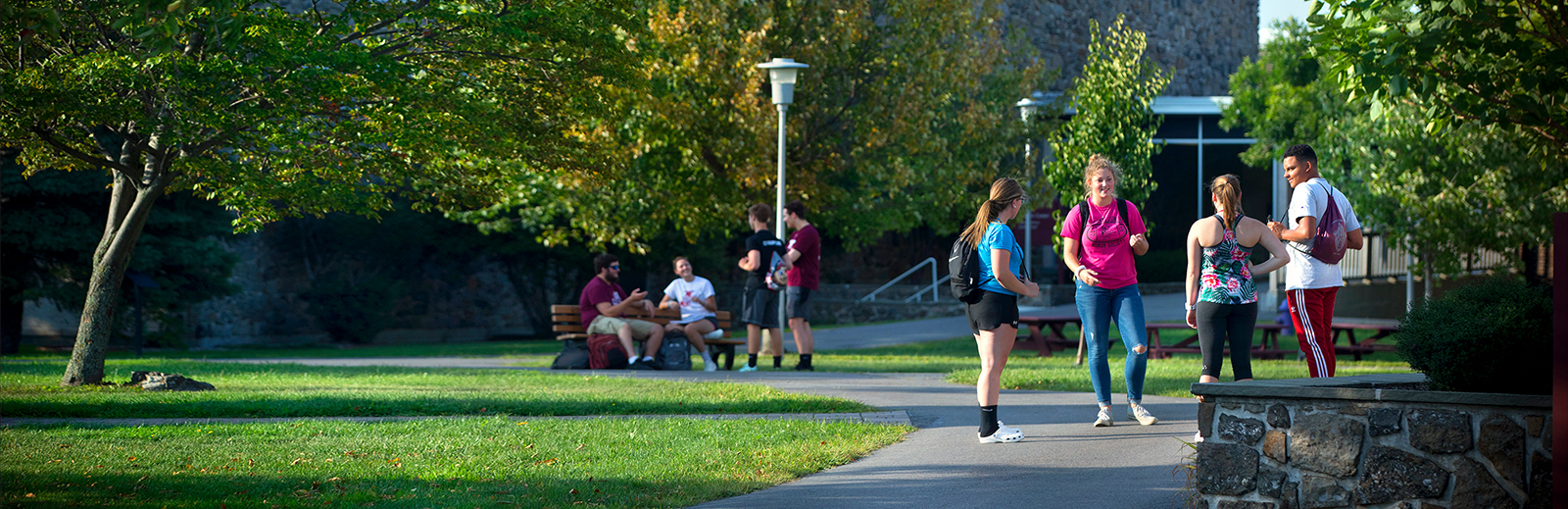 Two groups of students talking on campus.